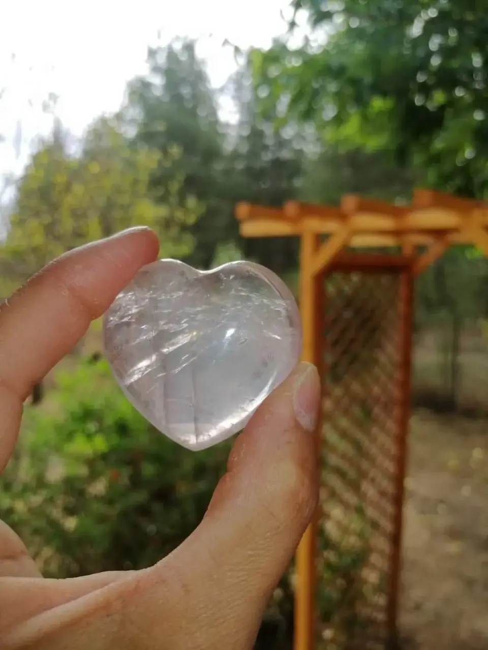 Un cœur de quartz rose tenu dans la main